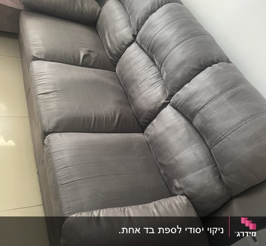 ספת בד תלת מושבית נקייה בסלון הבית